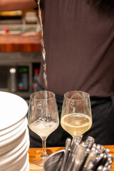 Pouring of txakoli or chacolí slightly sparkling very dry white wine produced in Spanish Basque Country in typical pinchos bar in old part of San Sebastian or Donostia, Spain