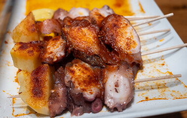 Typical snack of Basque Country, pinchos or pinxtos skewers with small pieces of bread, sea food, eggs, cheese, jamon served in bar in San-Sebastian or Bilbao, Spain, close up