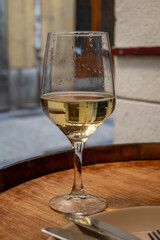 Glass of txakoli or chacolí slightly sparkling very dry white wine produced in Spanish Basque Country in typical pinchos bar in old part of San Sebastian or Donostia, Spain