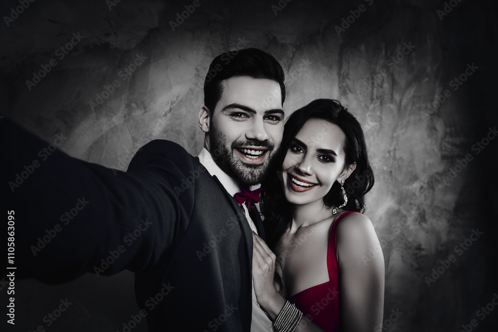 Poster self portrait of attractive trendy couple, gentlemen with stubble in tuxedo shooting selfie on front