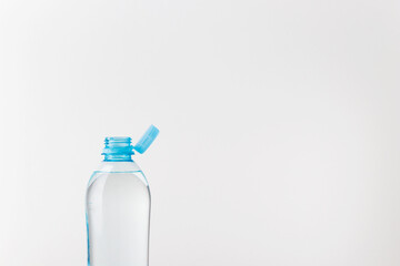 Bottle with a stationary plastic cap on a white background. The new design means the cap remains attached to the bottle after opening
