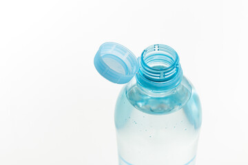 Close up of new cap attached to plastic bottle, connected to the neck of the bottle by solid tab attached to safety ring. They are intended to encourage recycling, as part of the fight against litter
