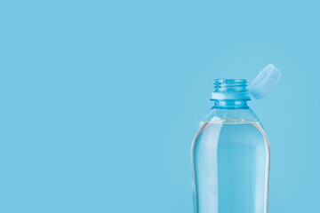 Bottle with a stationary plastic cap on a white background. The new design means the cap remains attached to the bottle after opening