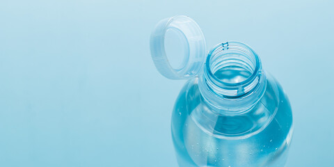 Close up of new cap attached to plastic bottle, connected to the neck of the bottle by solid tab...