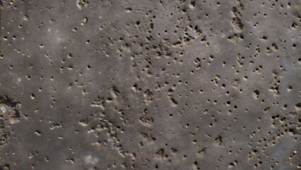 Close-up of a dark textured surface with holes and irregular patterns for background concept