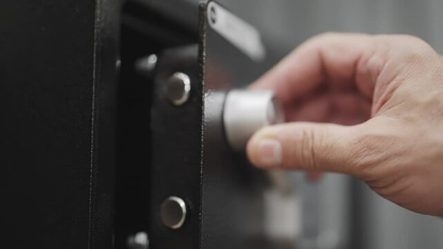 Hand opens a touchpad digital safe with a keypad sitting on a black surface. Thief robbery of hidden treasure from device with keyless entry system for a safe lockbox