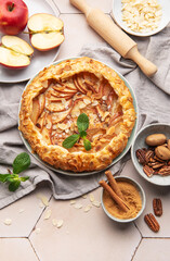 Delicious homemade apple galette decorated with almond flakes and fresh mint