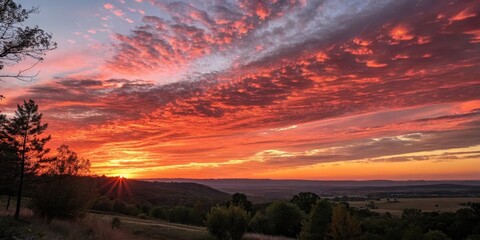Fiery Sunset Over Rolling Hills and Fields, a Breathtaking Display of Color in the Sky
