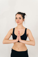 Obraz premium woman practices yoga with her arms folded across her chest