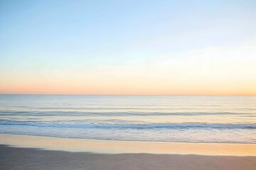 Fototapeta premium Serene sunset over calm ocean waves lapping gently on a sandy beach, pastel colors.
