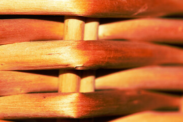 The texture of a wicker basket made of a light brown vine.