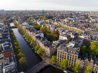 Historical Center of Amsterdam, Netherlands. Aerial Drone Shot of Traditional Dutch houses on narrow street and channel.