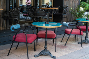 Outdoor seating area features vibrant chairs, a stylish table, and plants, creating an inviting space for relaxation and conversation