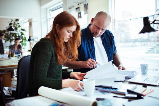 Young man and woman working together on a project in a startup company office