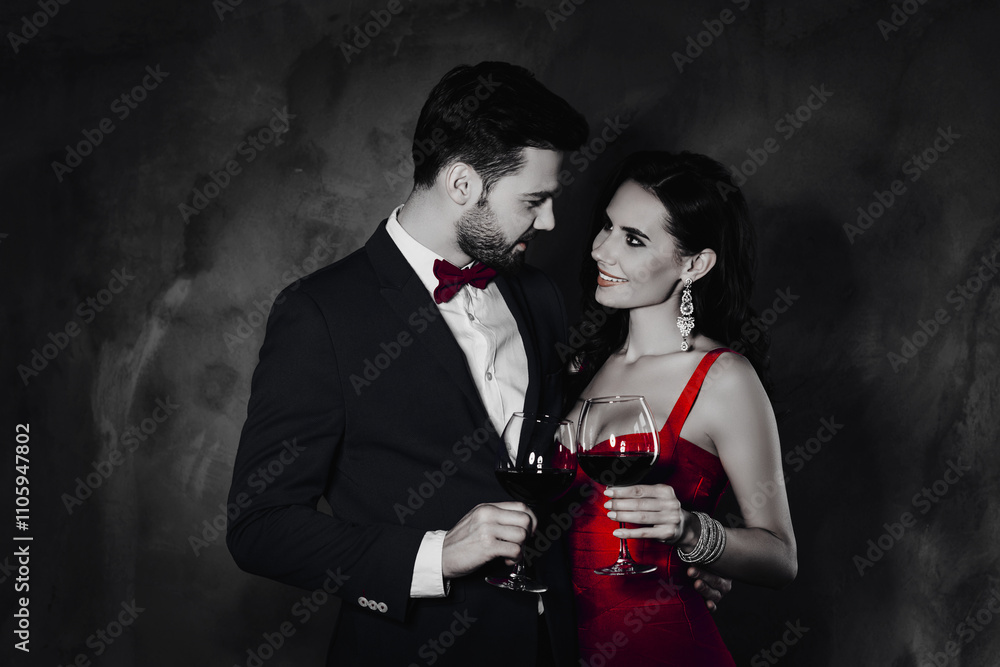 Poster portrait of romantic lovely couple having wineglasses with red wine in hands looking at each other, 