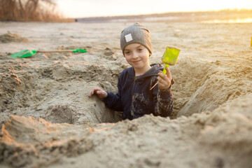 Child enthusiastically digging in the sand with a bright green shovel, capturing the essence of...