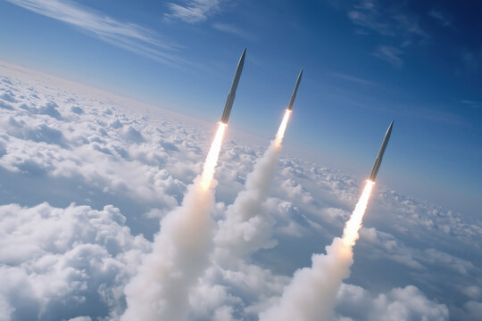 Three missiles flying high above the clouds, leaving contrails