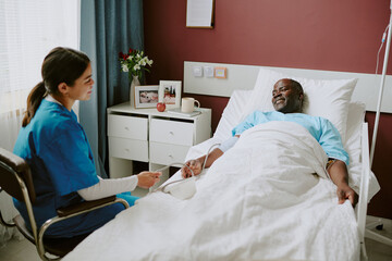 Nurse tending to bedridden patient in hospital room, providing care and compassion, medical...