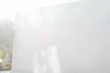 Clean, minimalist white wall background with subtle shadows and sunlight, perfect for product displays or text overlays.  Ideal for modern design projects.