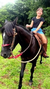 garota anda de cavalo em fazenda 
