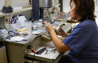 Dental technician working on prosthetic molds at the workbench