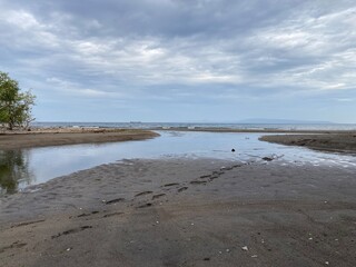 Sandbar is formed at low tide of water waves gently caress warm sand