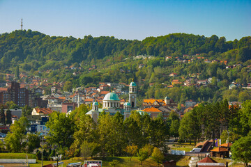 Panorama of the town Tuzla with church and trees and mountains and buildings under sunlight, Bosnia and Herzegovina