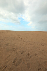background with desert sand dune and sky with a few clouds no people