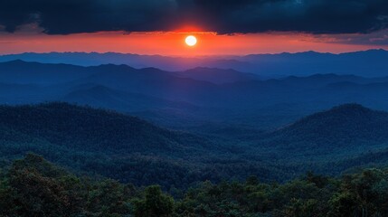 Obraz premium A serene sunset over rolling mountains, casting warm hues across a tranquil landscape.