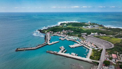 Aerial view of Taiwans serene harbor with boats and lush greenery on a clear day