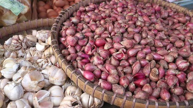 Pile of fresh garlic and red onions at traditional market Indonesia, for sale. Retail market