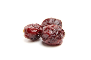 Close-up of three dried cranberries with a glossy surface and wrinkled texture. Perfect for snacks, baking, or illustrating healthy food concepts