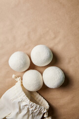 Wool Dryer Balls with Cotton Bag on Brown Paper Background
