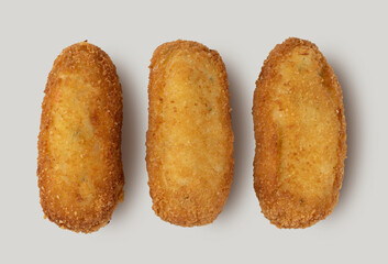 Crispy handmade chicken croquettes on a close-up view over a white background