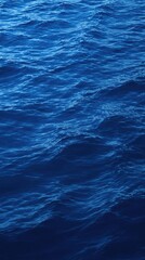 Fototapeta premium Deep indigo blue oceanic background with gentle undulations in the water , subtle color gradations, calmness, oceanic scenery, wavy lines
