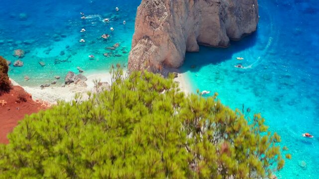 Reveal shot of dream beach. Aerial drone shot of Greece Limni Keri rock island. Mizithres limestone formation teal clear blue water with white sands green forest red dirt on cliffs in Zakynthos