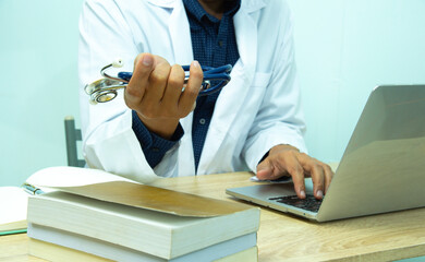 computer notebook and medical text book at desk in the hospital. Medical concept