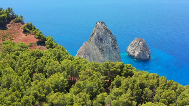Magical dream beach aerial reveal shot. Greece Limni Keri rock island. Mizithres limestone formation in Turquoise clear blue water with white sands and green forest on cliffs in Zakynthos