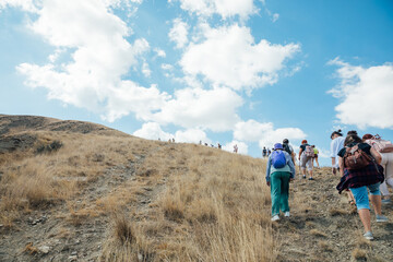 A group of tourists climbing to the top of a mountain on a hike trip