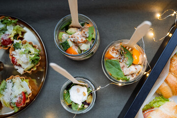 A beautifully arranged table, elegantly topped, filled with a variety of plates containing delicious food and bowls brimming with vibrant dishes, all complemented by wooden spoons