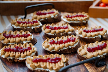 A wooden cutting board sits invitingly topped with delicious peanut butter and jelly sandwiches, showcasing a classic and beloved combination that many people enjoy for lunch or snacks