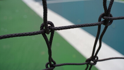 Close-up of tennis net, textured detail, abstract shapes, green and blue colors