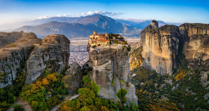 Panoramic aerial sunrise view of the Meteora mountains with Agia Triada monastery situaded on a cliff high over the valley, Greece