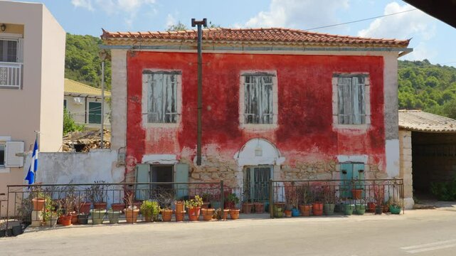 Picturesque facade of a traditional local house with stone painted red wall and windows in Exo Chora village of Zakynthos island, Ionian Sea, Greece