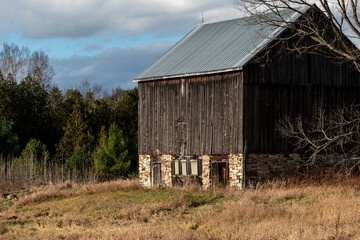 Obraz premium Rural Barn with Metal Roof and Stone Foundation Mid Fall Season