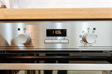 Obraz premium A sleek stainless steel oven is currently positioned on top of a polished wooden counter surface, indicating its role as an essential kitchen appliance in a home setting