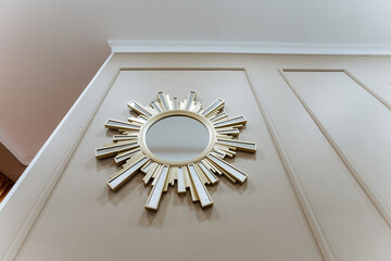 An Elegant Sunburst Mirror beautifully displayed on a Stylish Wall enhances the charm and appeal of...