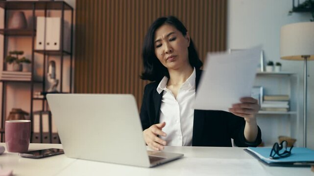 Middle-aged businesswoman experiences a hot flash while working in her office