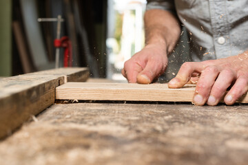 The carpenter manually mills the part