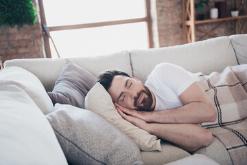 Photo of young man lying on soft comfy divan sleeping calm weekend indoors home room apartment